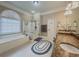 Bright bathroom with a soaking tub, glass shower, and double vanity with granite countertop at 710 Bentgrass Ct, Dacula, GA 30019