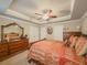 This bedroom view shows the dresser with mirror and the room's tray ceiling and neutral paint at 710 Bentgrass Ct, Dacula, GA 30019