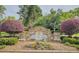 Elegant stone community entrance sign for Sterling Green, surrounded by colorful landscaping and trees at 710 Bentgrass Ct, Dacula, GA 30019