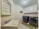 Bright laundry room with utility sink, plenty of counter space, and washer and dryer at 710 Bentgrass Ct, Dacula, GA 30019