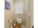 Small powder room with toilet, small window, and neutral colored walls at 710 Bentgrass Ct, Dacula, GA 30019