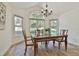 Traditional dining room with wood table and chairs, chandelier, large windows with natural light, and hardwood floors at 108 Shawville Ln, Peachtree City, GA 30269