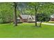 Traditional brick home featuring a lush green lawn and mature trees providing shade at 108 Shawville Ln, Peachtree City, GA 30269