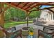 Covered outdoor firepit and seating area is surrounded by lush greenery at 108 Shawville Ln, Peachtree City, GA 30269