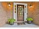 Close-up of a welcoming front door with sidelights, brick facade and decorative plants at 108 Shawville Ln, Peachtree City, GA 30269
