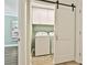 Functional laundry room with modern sliding door, washer, dryer, storage cabinets, and neutral decor at 108 Shawville Ln, Peachtree City, GA 30269