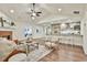 Open-concept living space with a brick fireplace, modern kitchen, and hardwood floors at 108 Shawville Ln, Peachtree City, GA 30269