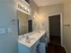 Bathroom featuring a double sink vanity, large mirror, lighting, and a doorway leading to a closet at 124 Sparkling Spring Trl, Mcdonough, GA 30252