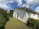 Side view of a charming home featuring bright siding, green lawn and chimney against a blue sky at 124 Sparkling Spring Trl, Mcdonough, GA 30252