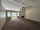 Spacious living room with plush carpeting, a fireplace, and expansive windows for natural light at 124 Sparkling Spring Trl, Mcdonough, GA 30252