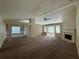 Open-concept living area with fireplace, large windows, plush carpet, and classic chandelier in the adjacent dining space at 124 Sparkling Spring Trl, Mcdonough, GA 30252