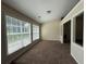 Sun-drenched sun room with large windows, carpet flooring, and an open view to the living area at 124 Sparkling Spring Trl, Mcdonough, GA 30252