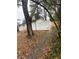 Exterior view of the white painted house, fenced yard, and lush backyard with mature trees, on a slightly cloudy day at 1905 Robinhill Ct, Tucker, GA 30084