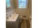 Updated bathroom featuring gray vanity with white countertop and brushed chrome faucet, along with window for natural light at 1905 Robinhill Ct, Tucker, GA 30084