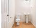 Small powder room with wood floors, toilet, and pedestal sink at 2717 High Creek Run, Dacula, GA 30019