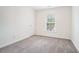 Neutral spare bedroom has plush carpet and a bright window at 2717 High Creek Run, Dacula, GA 30019