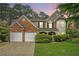 Charming two-story home featuring a manicured lawn, brick accents, and a convenient two-car garage at 2717 High Creek Run, Dacula, GA 30019