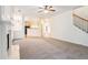 Open-concept living room showing fireplace, staircase, and view into kitchen area at 2717 High Creek Run, Dacula, GA 30019