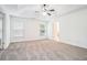 Spacious main bedroom with a tray ceiling, ceiling fan and large windows at 2717 High Creek Run, Dacula, GA 30019