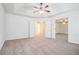 A large primary bedroom with neutral carpet, tray ceiling, and double doors at 2717 High Creek Run, Dacula, GA 30019