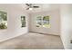 Bright bedroom featuring neutral walls, carpet floors, a ceiling fan with light, and two windows with views of the outdoors at 3294 Renault Se Rd, Atlanta, GA 30354