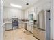Efficient kitchen featuring stainless steel appliances, white cabinets, and practical tile flooring for easy maintenance at 3665 Pine St, Atlanta, GA 30340