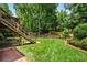 Expansive backyard features a wooden deck, lush green grass, mature trees, and a charming picket fence at 3944 Blustery Ne Way, Marietta, GA 30066