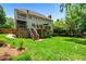Backyard view of home's exterior, wooden deck, and green lawn surrounded by mature trees and fencing at 3944 Blustery Ne Way, Marietta, GA 30066