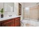 Well-lit bathroom with wood vanity, full bathtub, tile surround, and frosted sliding shower doors at 3944 Blustery Ne Way, Marietta, GA 30066