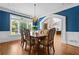 Dining room with dark blue walls, hardwood floors, wainscoting, chandelier, and natural light at 3944 Blustery Ne Way, Marietta, GA 30066