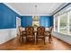 Formal dining room is adorned with blue walls, a chandelier, and wainscoting, perfect for entertaining at 3944 Blustery Ne Way, Marietta, GA 30066
