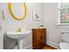 Charming powder room with pedestal sink, gold mirror, and decorative accents at 3944 Blustery Ne Way, Marietta, GA 30066