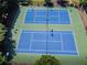Aerial view of two well-maintained, fenced tennis courts on a green surface, perfect for sports enthusiasts at 3944 Blustery Ne Way, Marietta, GA 30066