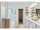 Double sink bathroom featuring grey cabinets, two mirrors, and an adjacent toilet at 379 Morgan Rd, Carrollton, GA 30116