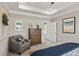 Bright bedroom with tray ceiling, chair, dresser, and adjacent bathroom at 379 Morgan Rd, Carrollton, GA 30116