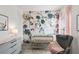 A cozy Bedroom with a floral accent wall, crib, and comfortable rocking chair at 379 Morgan Rd, Carrollton, GA 30116