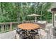 Outdoor deck features a table and seating surrounded by lush trees creating a private oasis at 4045 Bridle Ridge Dr, Suwanee, GA 30024
