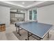 Spacious game room with a ping pong table, connects to a living area with natural light at 4045 Bridle Ridge Dr, Suwanee, GA 30024