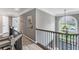 Upstairs hallway features rod iron railing, hardwood floors, an arched window, and neutral paint at 4045 Bridle Ridge Dr, Suwanee, GA 30024