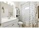Well-lit bathroom with white cabinets, shower, and decorative shower curtain at 5744 Cypress Bluff Ln, Hoschton, GA 30548