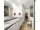 This bathroom offers double sinks with white cabinets and a walk in shower at 5744 Cypress Bluff Ln, Hoschton, GA 30548