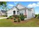 Beautifully landscaped front yard showcasing lush greenery and charming stone accents on the facade at 5744 Cypress Bluff Ln, Hoschton, GA 30548