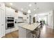 Bright kitchen showcases white cabinets, granite countertops, stainless steel appliances, and a convenient center island at 5744 Cypress Bluff Ln, Hoschton, GA 30548
