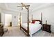 This bedroom features white walls, carpeted floors, and a four poster bed at 5744 Cypress Bluff Ln, Hoschton, GA 30548