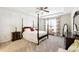 This bedroom offers a ceiling fan, a tray ceiling, and a four poster bed at 5744 Cypress Bluff Ln, Hoschton, GA 30548