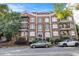 Classic brick apartment building featuring wrought iron balconies and arched doorway with lush landscaping at 61 16Th Ne St # 4, Atlanta, GA 30309