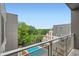 This balcony view shows a view of the swimming pool and lush green trees beyond the buildings at 775 Juniper Ne St # 612, Atlanta, GA 30308