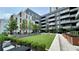 Beautiful courtyard with manicured lawn, mature trees, lounge seating, and views of the condo building at 775 Juniper Ne St # 612, Atlanta, GA 30308