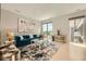 Bright living room featuring a plush blue sofa, modern art, and an open floor plan with large windows at 775 Juniper Ne St # 612, Atlanta, GA 30308