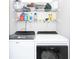 Functional laundry room with modern washer and dryer and ample storage on wire shelving at 9155 Nesbit Ferry Rd, Alpharetta, GA 30022